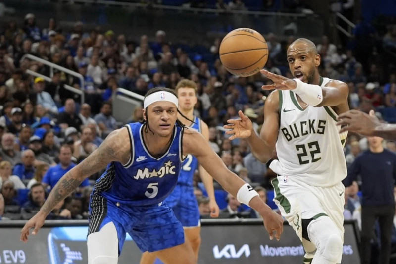El escolta de los Bucks de Milwaukee Khris Middleton (22) pasa la bola ante el escolta del Magic de Orlando Paolo Banchero (5), durante la primera mitad del juego de baloncesto de la NBA.