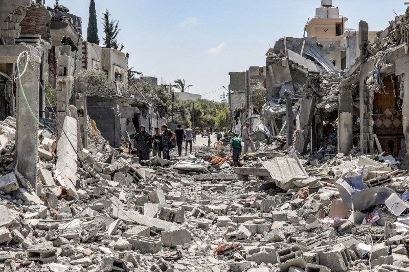 La gente busca entre los escombros de un edificio derrumbado en el lado este del campamento de Maghazi para refugiados palestinos en el centro de la Franja de Gaza el 15 de abril de 2024 en medio del conflicto en curso en el territorio palestino entre Israel y el grupo militante Hamas.