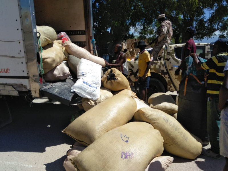Autoridades desmontan sacos de ropas usadas de un camión en el que también llevaban sacos de arroz que fueron retenidos para que no pasaran hacia Haití.