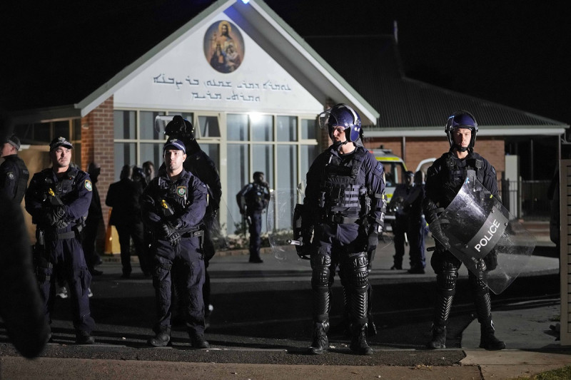 Policías hacen guardia frente a la iglesia ortodoxa asiria en Sydney, después de que un hombre fue arrestado por apuñalar a varias personas.