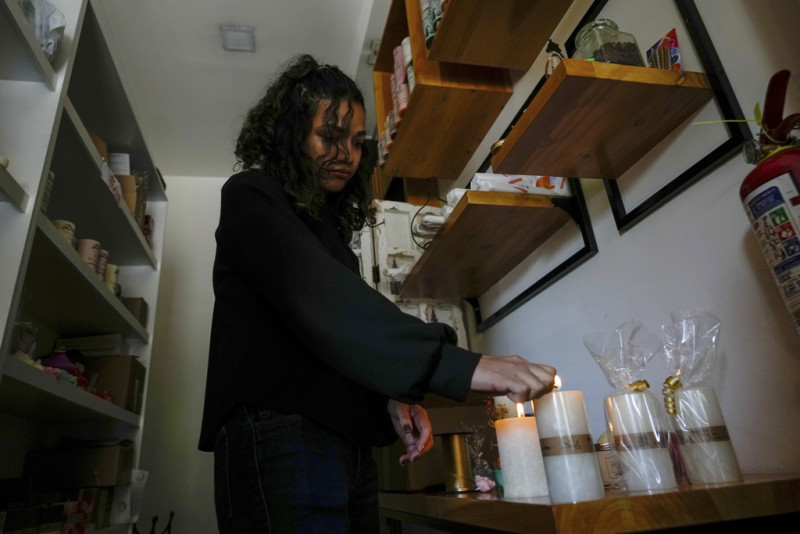 Una mujer enciende velas en Ecuador