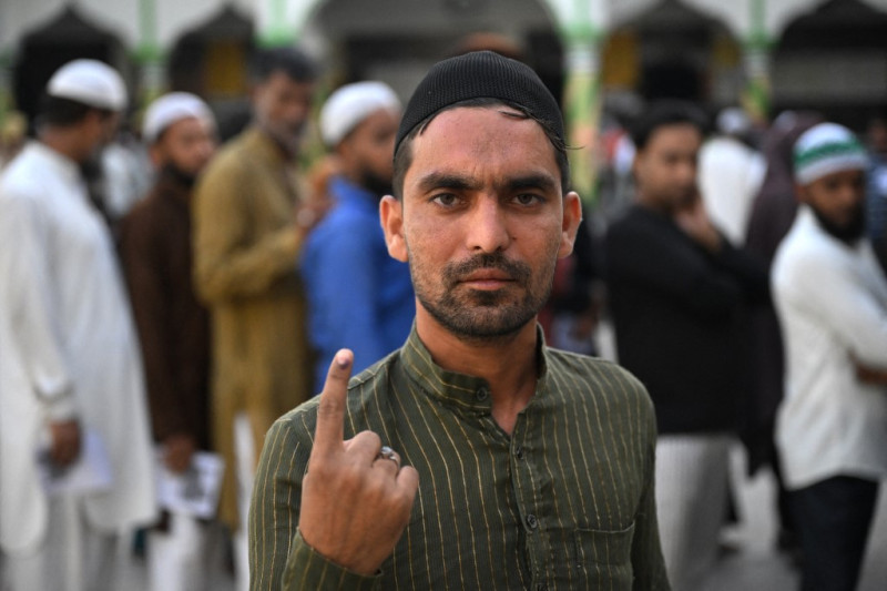 Un musulmán muestra su dedo entintado