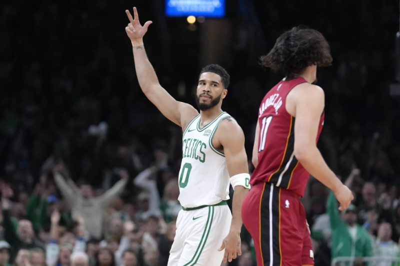 El alero de los Celtics de Boston Jayson Tatum (0) celebra frente al armador mexicano del Heat de Miami Jaime Jaquez Jr. (11), durante la primera mitad del Juego 1 de la serie de primera ronda de postemporada de la NBA.