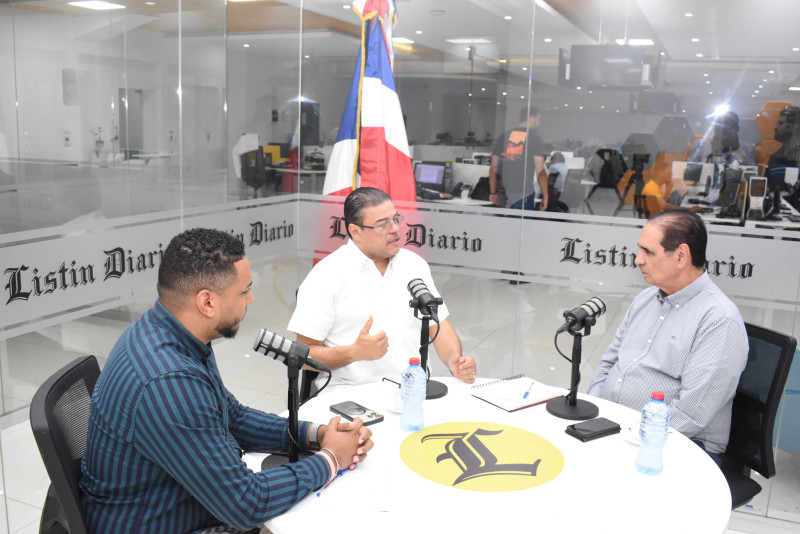 El ministro Francisco Camacho al momento de responder una de las preguntas del editor deportivo Héctor J. Cruz en el Café Deportivo.  Figura el redactor Jorge Luis Torres.