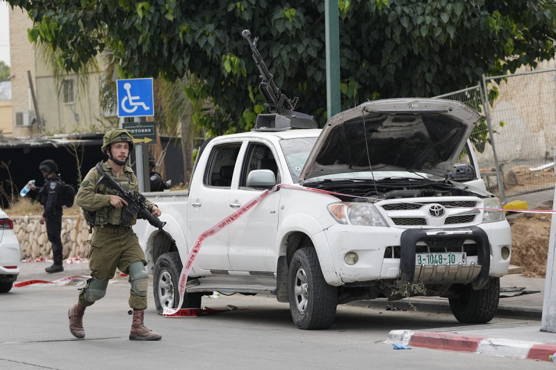 Un soldado israelí pasa junto a una camioneta utilizada por milicianos palestinos en Sderot, Israel, el sábado 7 de octubre de 2023.