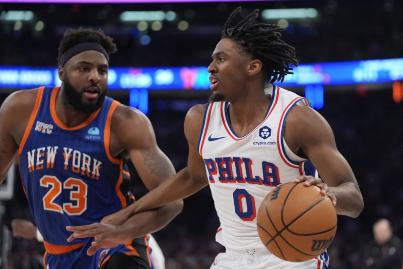 Tyrese Maxey de los Philadelphia 76ers busca pasar mientras Mitchell Robinson de los New York Knicks lo defiende.