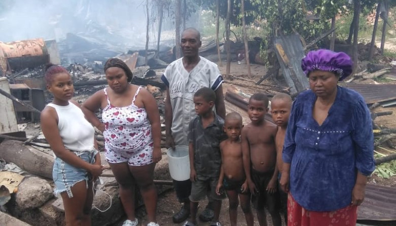 Familia posando junto a los escombros que dejó el sinientro.