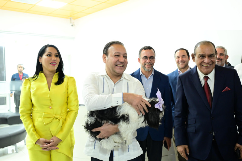 Abel Martínez sostiene a su mascota durante su visita a la redacción central de Listín Diario. A su izquierda la presidenta de la FEDDA, y a su derecha el director del diario, Miguel Franjul.