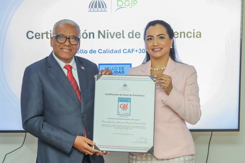 El director general de Jubilaciones y Pensiones, Juan Rosa, recibe la certificación de mano de la viceministra del MAP, Hadeline Matos.