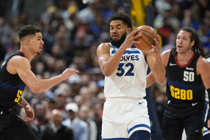 Karl-Anthony Towns, de Minnesota, defiende el balón de Michael Porter Jr. y Aaron Gordon luego de atrapar un rebote.