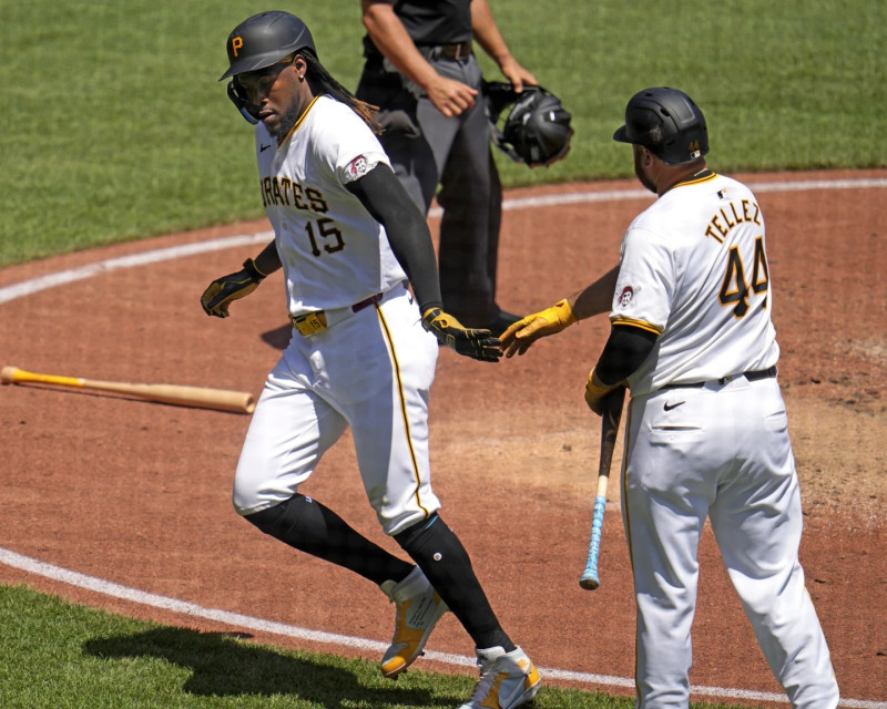 Oneil Cruz, de los Piratas, es recibido en el plato por el coach Rowdy Tellez tras anotar una carrera.