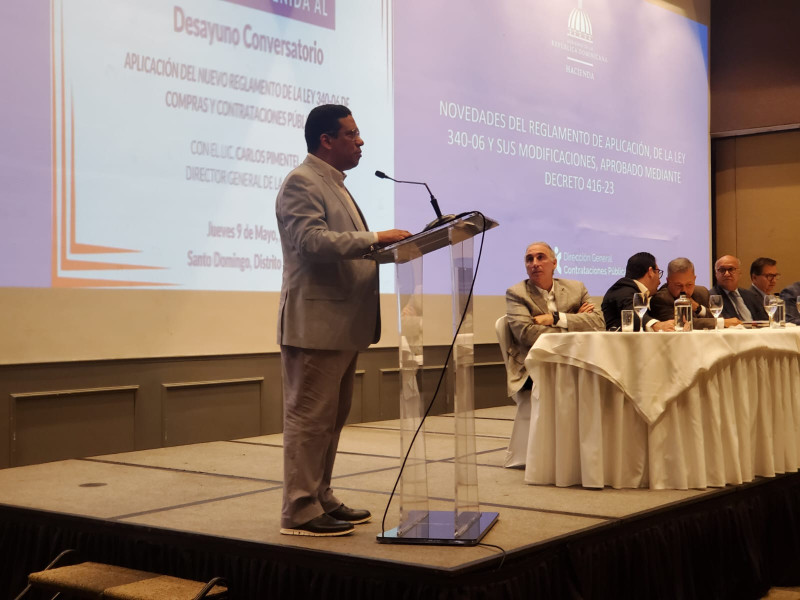 El director de la Dirección General de Contrataciones Públicas (DGCP), Carlos Pimentel, particia en un conversatorio con la UNE.