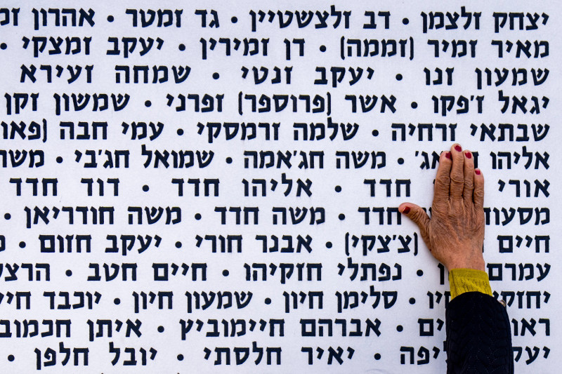 Una mujer toca ayer la pared con los nombres de soldados israelíes fallecidos en el sitio conmemorativo en Latrun, Israel.