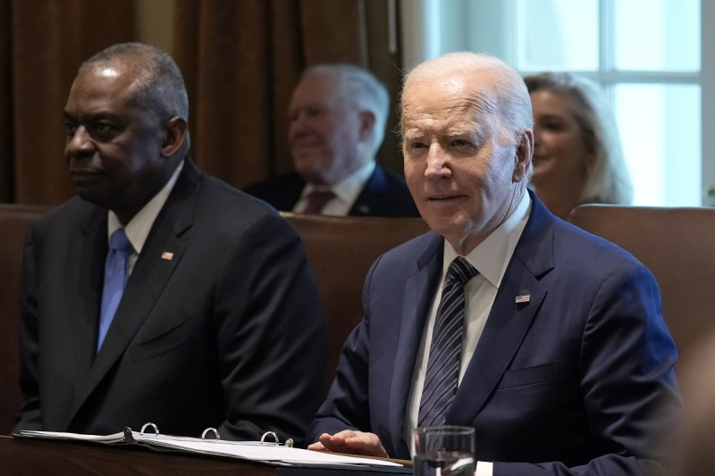 El presidente estadounidense Joe Biden, derecha, sentado al lado del secretario de Defensa, Lloyd Austin, a la espera de que los periodistas abandonen una sala de la Casa Blanca, antier en Washington.