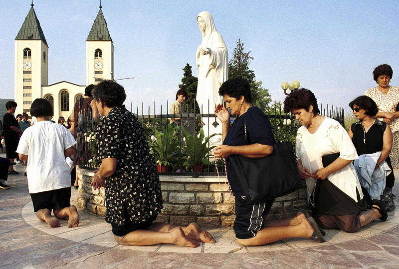 Fieles de la iglesia católica bosnia rezan durante la fiesta de la Asunción en Medjugorje, a unos 120 kilómetros al sur de la capital de Bosnia, Sarajevo, el 15 de agosto de 2000.