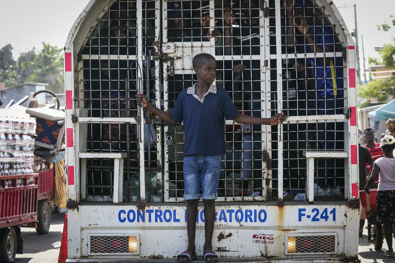 Un niño viaja de pie en la parte trasera de un camión que contiene a haitianos detenidos por las autoridades migratorias dominicanas, el viernes 17 de mayo de 2024, en Dajabón, República Dominicana.
