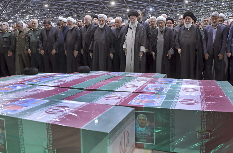 En esta fotografía publicada por un sitio web oficial de la oficina del líder supremo iraní, el líder supremo Ayatollah Ali Khamenei, de centro derecha con turbante negro, dirige una oración sobre los ataúdes cubiertos con banderas del difunto presidente Ebrahim Raisi y sus compañeros que fueron asesinados.