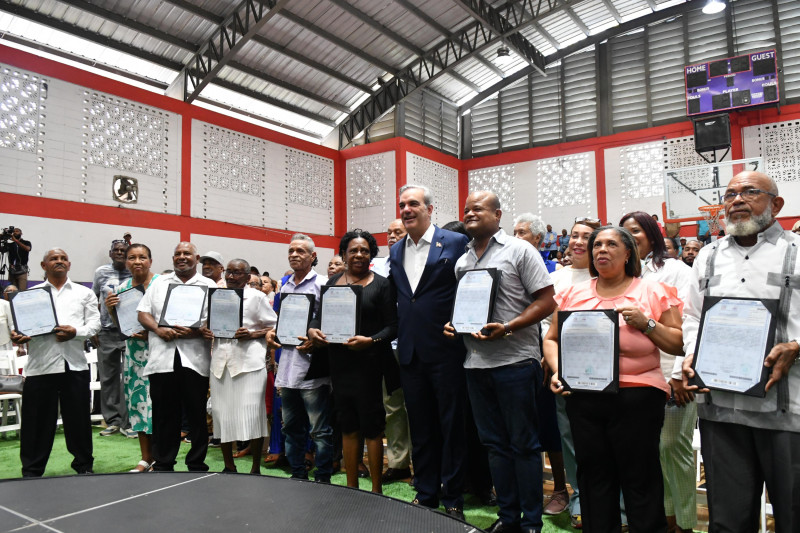 Fotografía muestra al presidente Luis Abinader entregando títulos de propiedad en Santo Domingo Este.