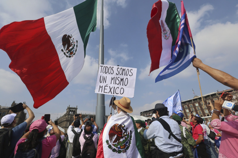 Una persona sostiene un cartel con la frase "Todos somos un mismo México" durante un mitin convocado por la oposición para llamar al voto en las elecciones presidenciales del 2 de junio, en la Plaza del Zócalo, en Ciudad de México, el 19 de mayo de 2024.