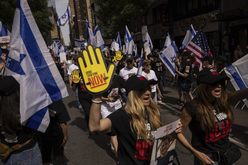 Manifestantes portan banderas y carteles durante un desfile en apoyo a Israel, el domingo 2 de junio de 2024, en Nueva York.