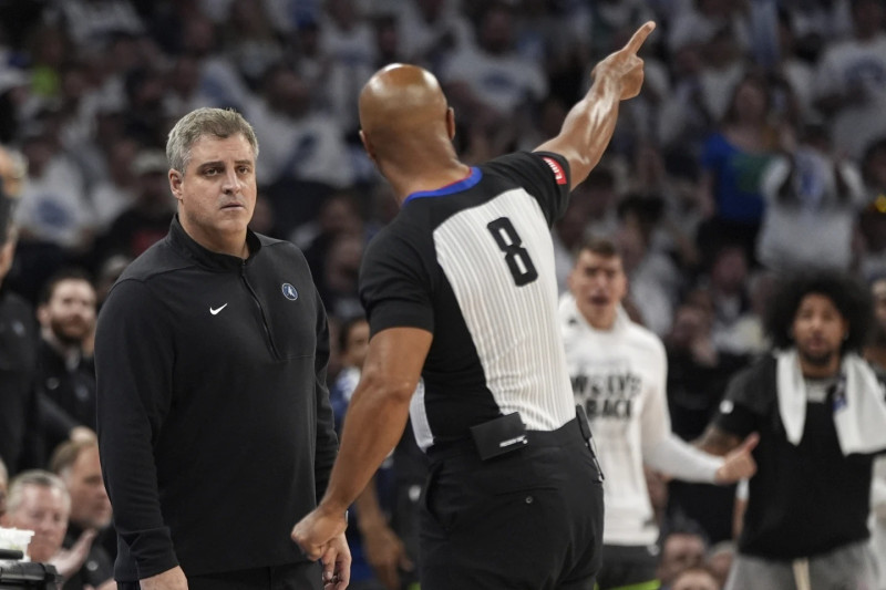 El entrenador asistente de los Minnesota Timberwolves, Micah Nori, izquierda, escucha al árbitro Marc Davis (8) explicar una llamada.