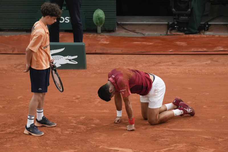 Novak Djokovic descansa ante un recogepelotas en su partido del lunes frente a Francisco Cerúndolo.