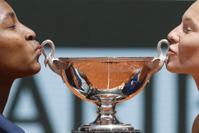 Katerina Siniakova y Coco Gauff besan la copa de campeonas.