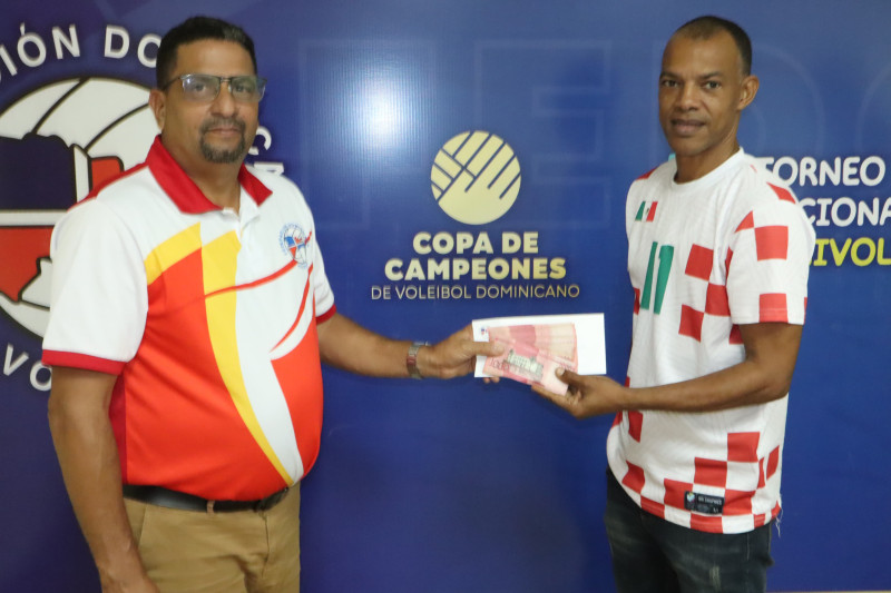 Francisco José Fernández, tesorero de la Federación Dominicana de Voleibol, galardona a Jorge Luis Mercedes, secretario de la Asociación del Distrito, primer lugar de la Copa de Campeones en la rama femenina.
