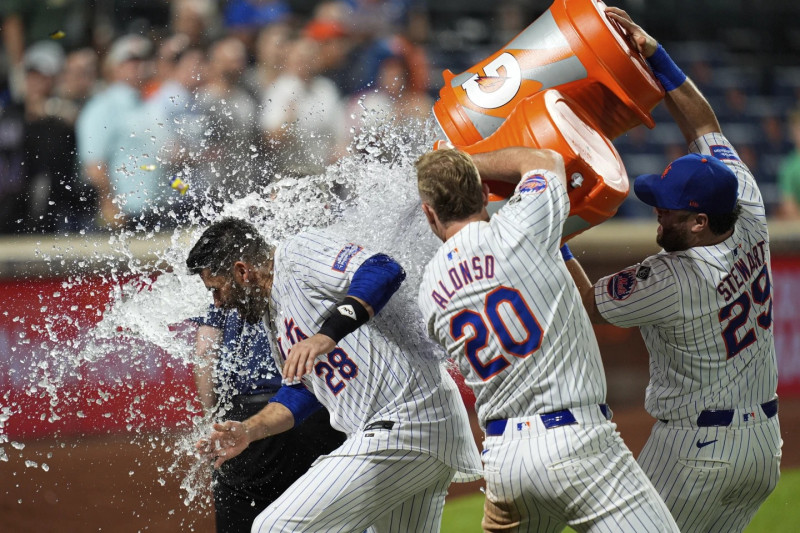 J.D. Martínez es bañado con agua por D.J. Stewart y Pete Alonso tras decidir la victoria de los Mets con un cuadrangular.