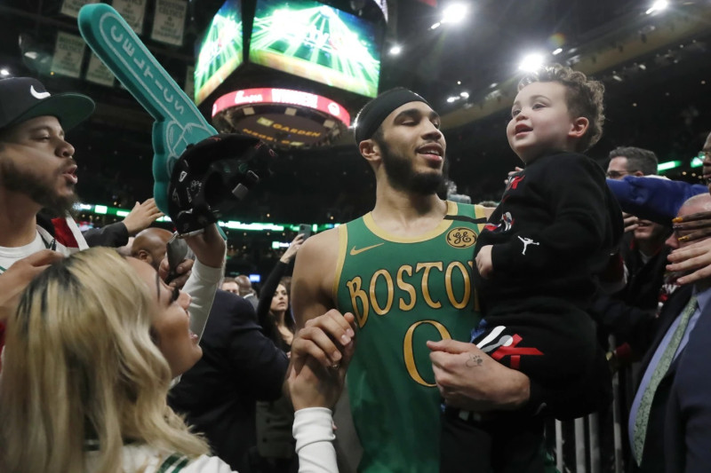 Jayson Tatum mientras salía de la cancha sosteniendo a su pequeño hijo Deuce luego de una victoria de los Celtics sobre los Clippers en 2020.