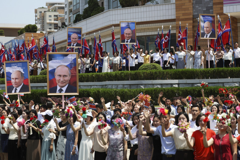 Personas, con retratos del presidente ruso Vladimir Putin