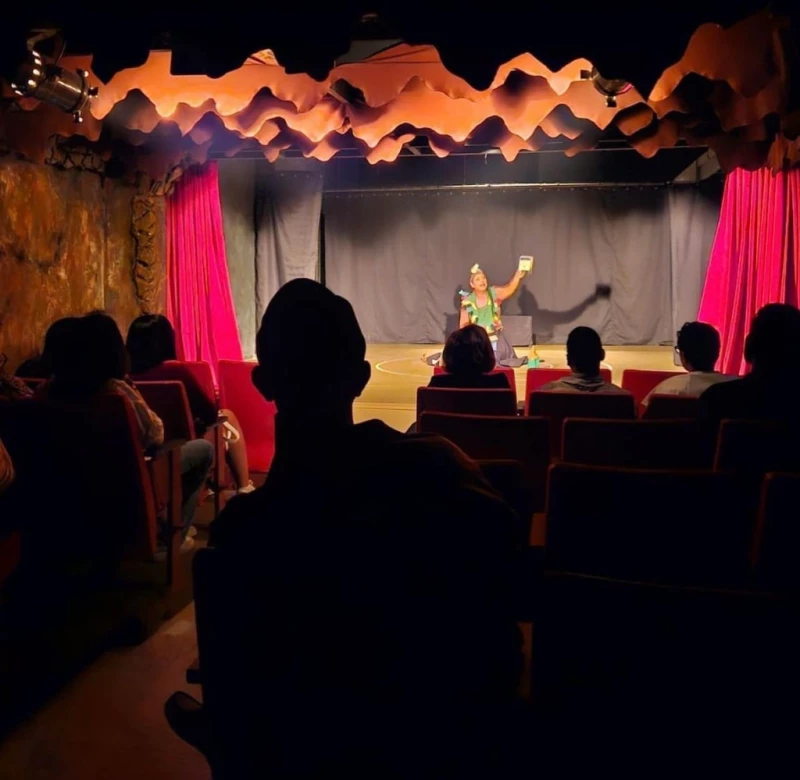 Imagen de la sala teatral La Gruta. Al fondo, Lucina E. Jiménez desde el escenario, en un ensayo con público.