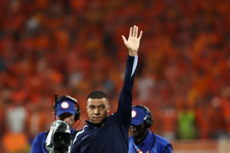 El delantero francés Kylian Mbappé saluda al público tras el empate 0-0 contra Países Bajos, un encuentro en el que no participó por precaución tras fracturarse la nariz.