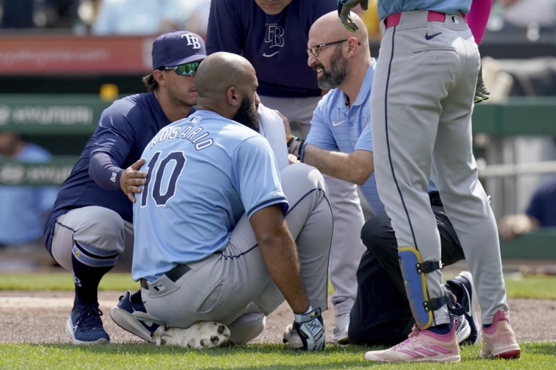 Amed Rosario es atendido por personal médico de Tampa tras ser golpeado en el juego ante los Piratas.