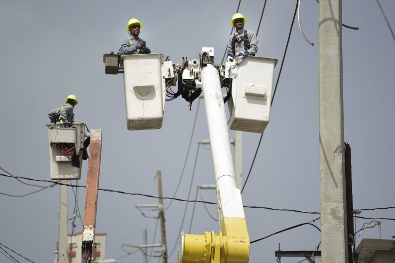 Obreros reparan cables eléctricos dañados por el huracán María en la comunidad Cantera en San Juan, Puerto Rico, el 19 de octubre del 2017.