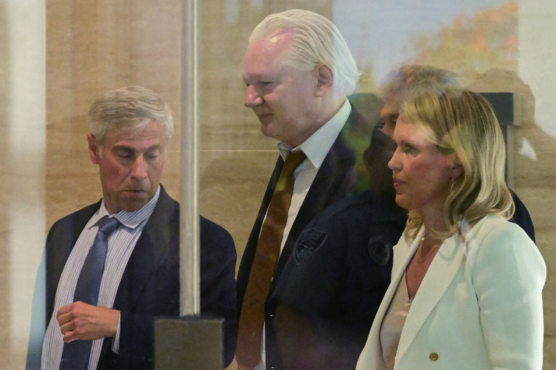 Julian Assange (C), y su abogada Jennifer Robinson (R), caminan por el área de seguridad a su llegada al Tribunal Federal de Estados Unidos en la Commonwealth de las Islas Marianas del Norte