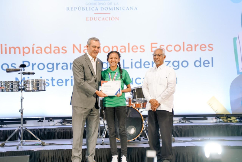 El presidente Luis Abinader, y el ministro de Educación, Ángel Hernández, entregan el premio a una estudiante.