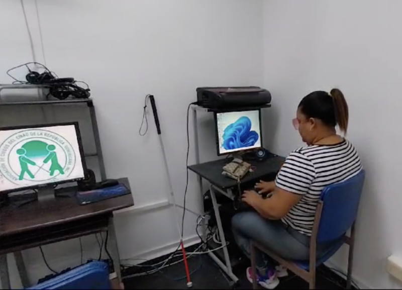 Uno de las estudiantes de la Asociación de Ciegos del Cibao (ASICIRD) operando la computadora.