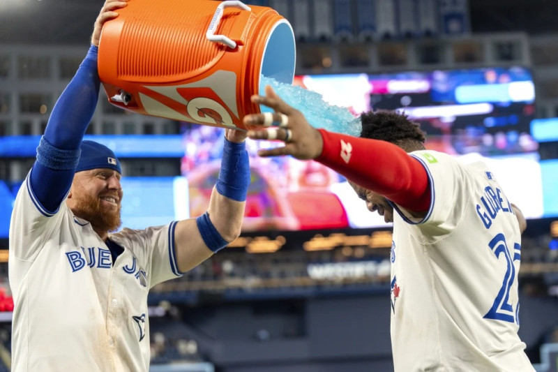 Justin Turner, de los Azulejos moja con bebida hidratante a su compañero de equipo el dominicano Vladimir Guerrero Jr. luego de vencer a los Yankees.