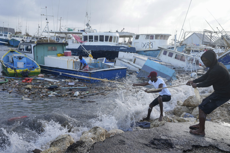 Pescadores tiran de un barco dañado por el huracán Beryl de regreso al muelle en Bridgetown Fisheries en Barbados, el lunes 1 de julio de 2024.
