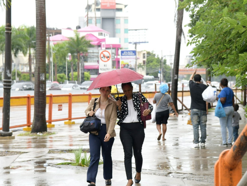 Personas caminan con paraguas en las calles del gran Santo Domingo, en medio del huracan Berly
