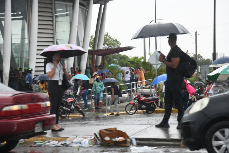 Personas se dirigen al metro bajo lluvia