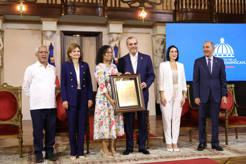 El presidente Luis Abinader cuando entregaba el premio a una maestra junto a Raquel Peña, Raquel Arbaje, Ángel Hernández y Franklin García Fermín.