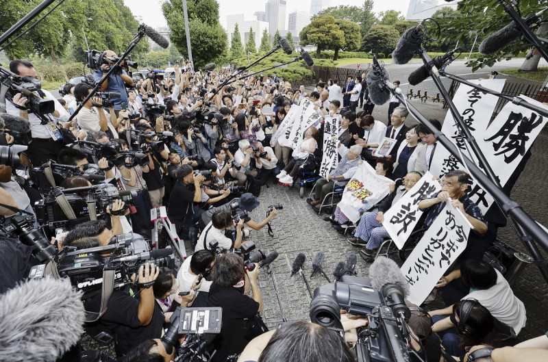 Demandantes, sus abogados y simpatizantes sostienen ayer letreros que dicen “Ganamos la demanda” afuera de la Corte Suprema en Tokio, Japón.