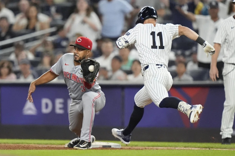 Anthony Volpe (11), de los Yankees, es retirado en la primera base mientras Jeimer Candelario, de los Rojos, atrapa la pelota durante la novena entrada del juego.