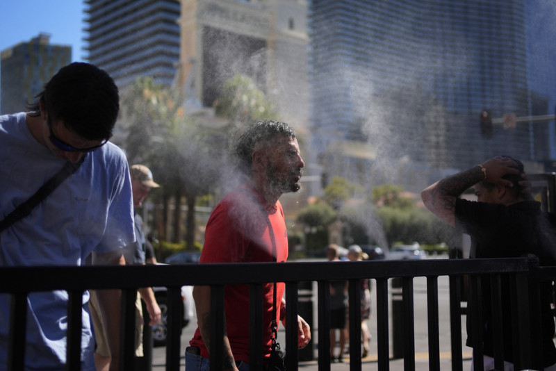 La gente se refresca en vaporizadores a lo largo del Strip de Las Vegas