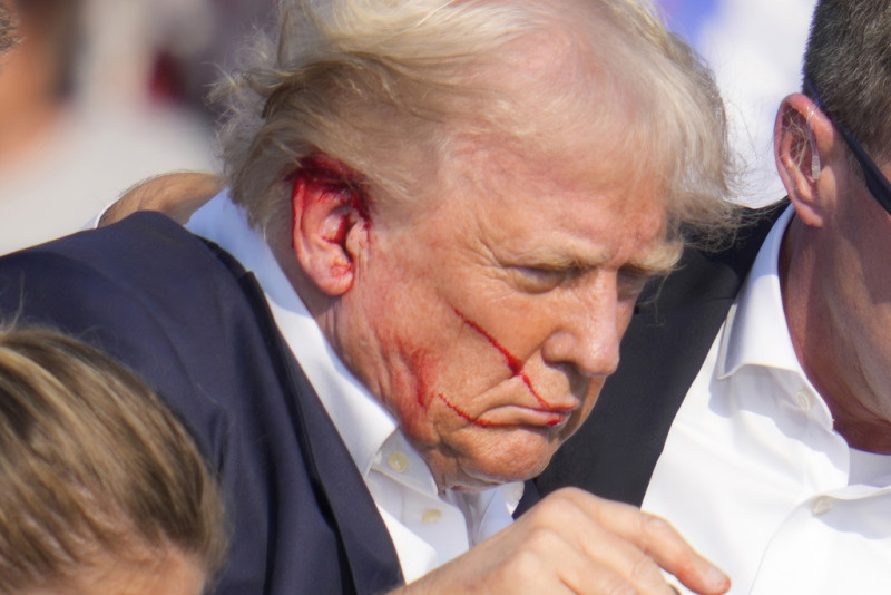 El expresidente Donald Trump es rodeado por agentes del Servicio Secreto mientras le ayudan a bajar del escenario en un acto de campaña en Butler, Pensilvania, el sábado 13 de julio de 2024
