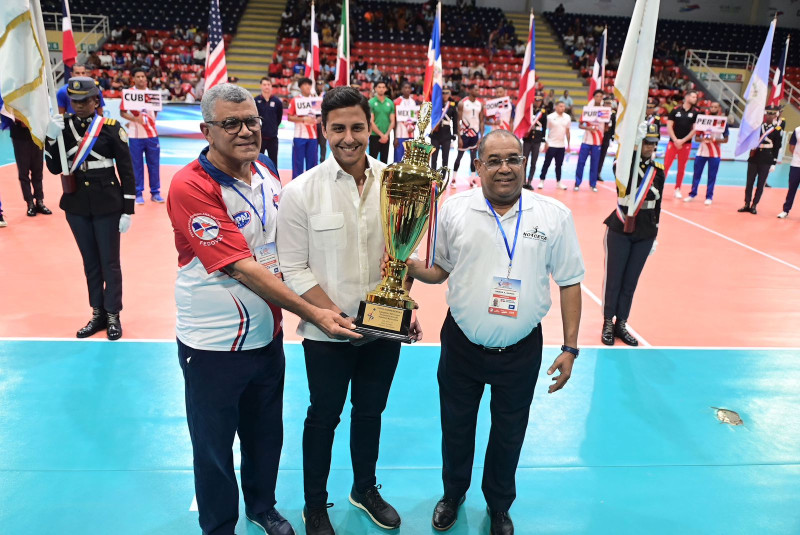 Rafael Villalona y Alexis García reciben de manos de Raymond Rodríguez, director de Deportes de BanReservas, la Copa BanReservas que se disputa en la XVII Copa Panamericana de Voleibol Masculino