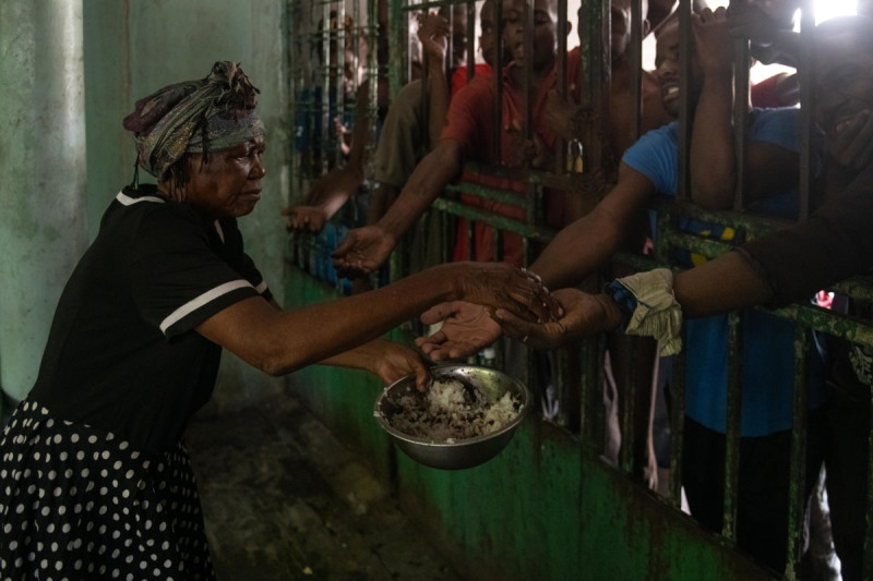 Una mujer da comida a hombres en el centro psiquiátrico Mars & Kline, el 8 de julio 2024, en el centro de Puerto Príncipe (Haití). Unos 60 pacientes pasan hambre en el centro psiquiátrico Mars & Kline, en el corazón de Puerto Príncipe, en el que falta lo necesario para satisfacer las necesidades básicas de los internos, como material de limpieza, agua potable, electricidad, alimentos y medicamentos.