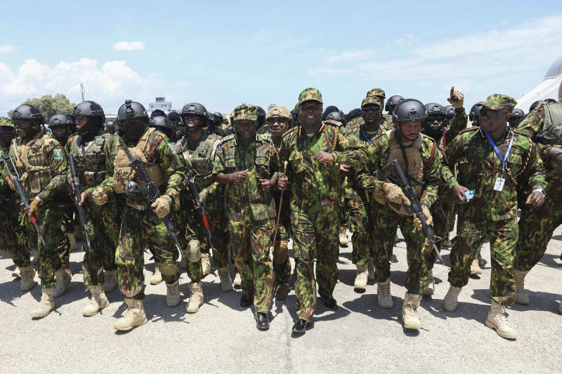Policías kenianos, que forman parte de una fuerza multinacional respaldada por la ONU, cantan y bailan en la pista tras aterrizar ayer en el Aeropuerto Internacional Toussaint Louverture en Puerto Príncipe.